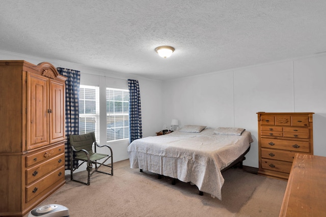 bedroom with a textured ceiling and light carpet