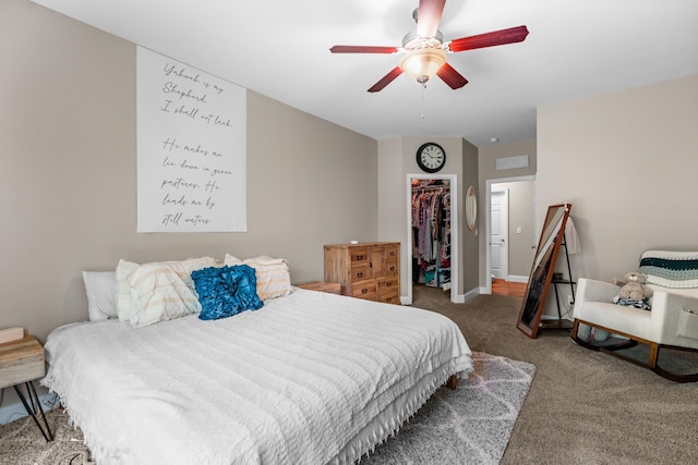 carpeted bedroom with ceiling fan, a spacious closet, baseboards, and a closet
