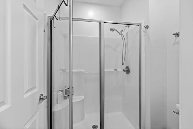 bathroom featuring a stall shower and toilet