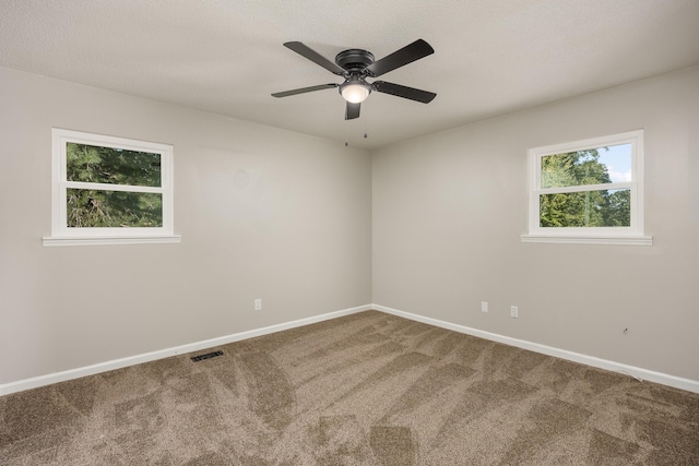 carpeted spare room featuring a textured ceiling and ceiling fan