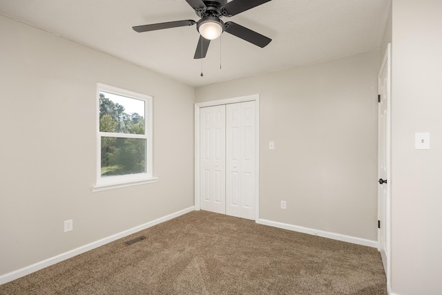 unfurnished bedroom featuring carpet flooring, a closet, and ceiling fan