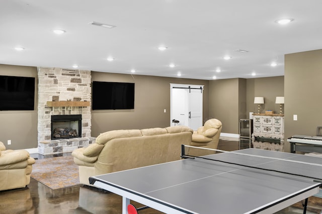 game room with a fireplace and a barn door