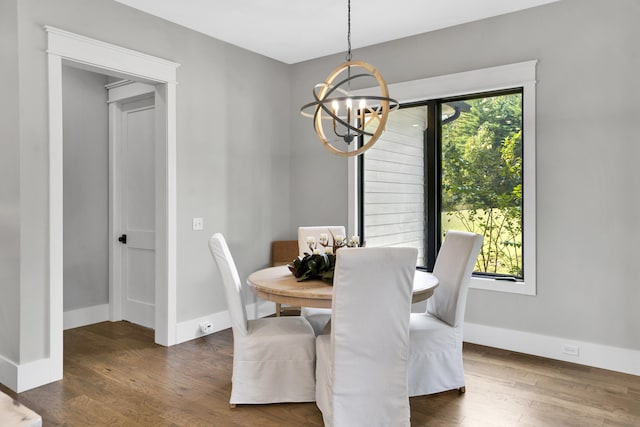 dining room featuring dark wood-type flooring and an inviting chandelier