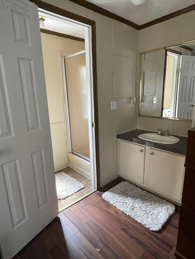 bathroom featuring an enclosed shower, vanity, hardwood / wood-style flooring, and crown molding