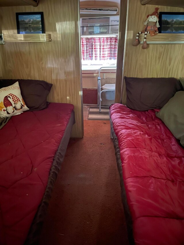 carpeted bedroom with wood walls