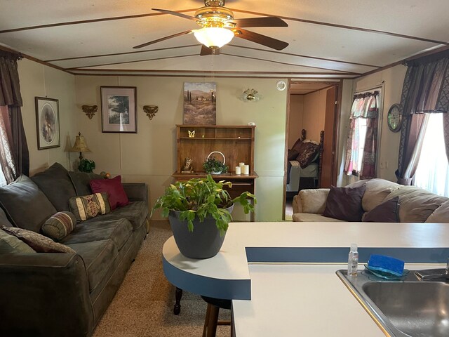 living room featuring sink, vaulted ceiling, ceiling fan, and carpet