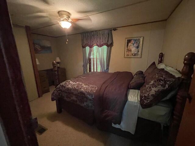 carpeted bedroom featuring a textured ceiling and ceiling fan