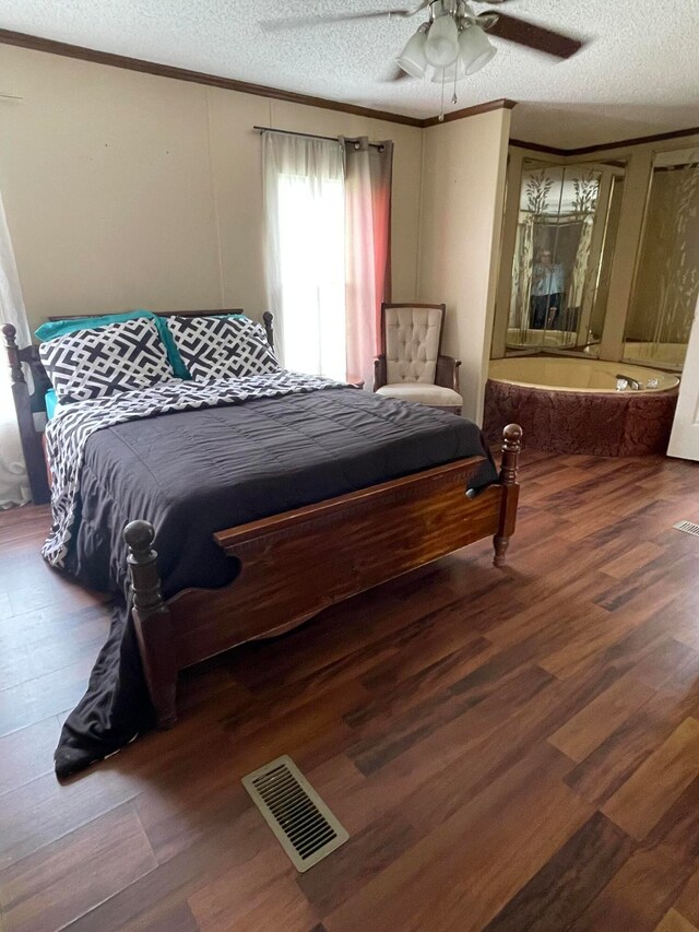 bedroom with ceiling fan, ornamental molding, dark hardwood / wood-style flooring, and a textured ceiling