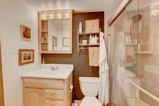 bathroom featuring an enclosed shower, toilet, and vanity