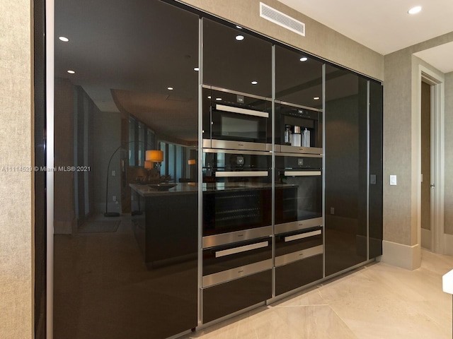 kitchen featuring double oven and light tile floors