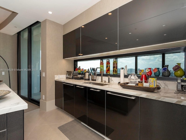 bar with light tile flooring, sink, and light stone counters