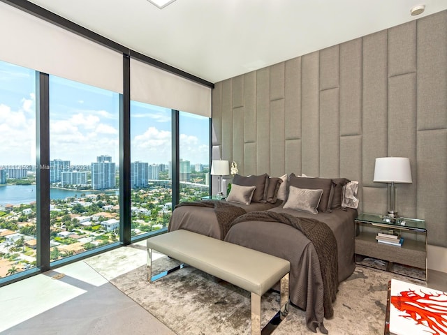 tiled bedroom with a water view, a wall of windows, and multiple windows