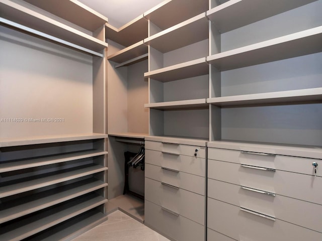 spacious closet with light tile flooring