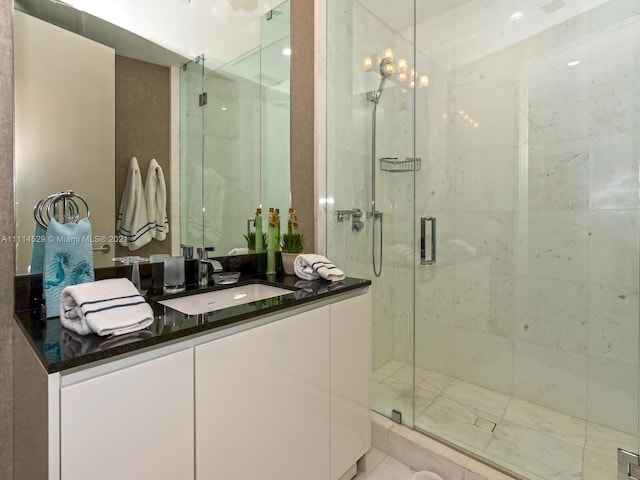 bathroom featuring a notable chandelier, tile flooring, a shower with shower door, and vanity