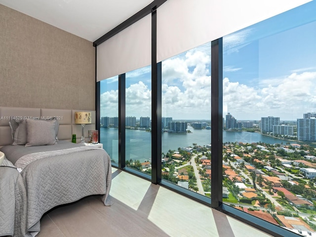 bedroom with a water view and a wall of windows