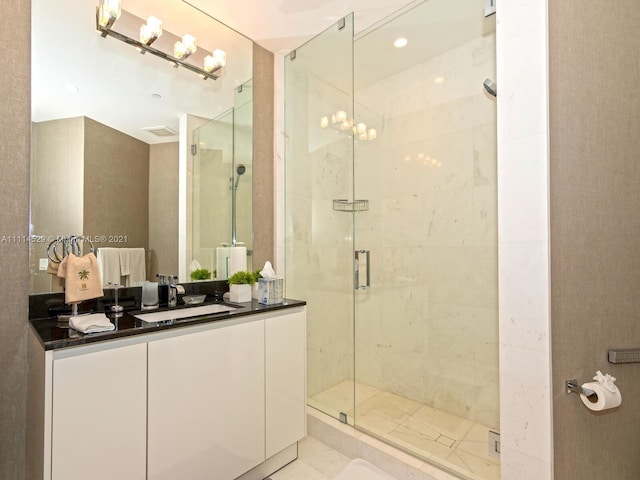 bathroom with vanity with extensive cabinet space, tile flooring, a shower with shower door, and an inviting chandelier