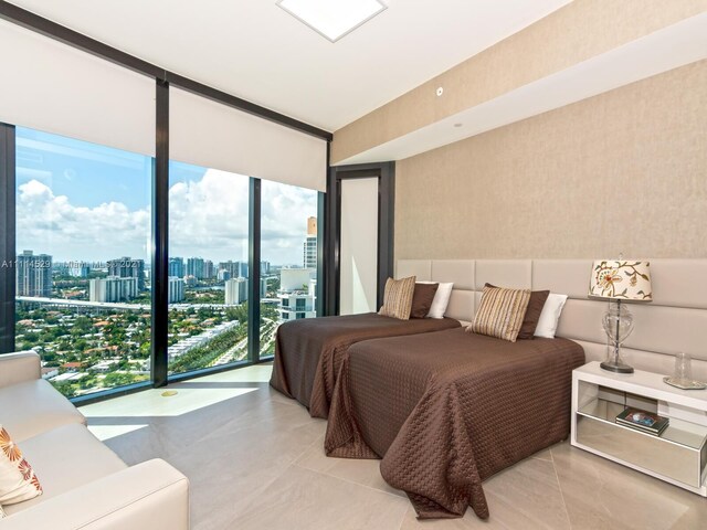 bedroom with access to exterior, a wall of windows, and light tile floors