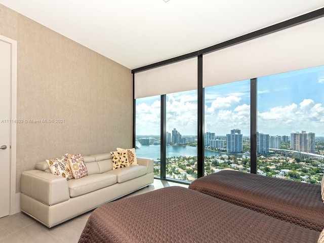 bedroom featuring a water view, light tile flooring, expansive windows, and multiple windows