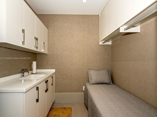 bedroom with sink and light tile floors