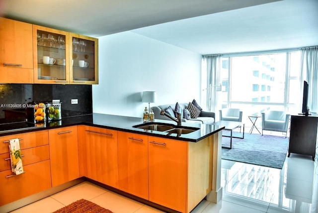 kitchen featuring sink, tasteful backsplash, light tile floors, and kitchen peninsula