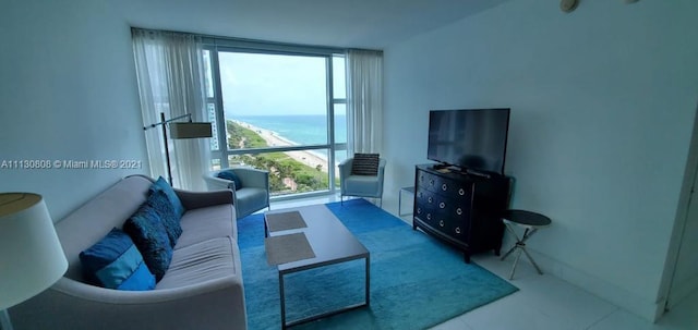 living room with floor to ceiling windows, tile floors, and a water view