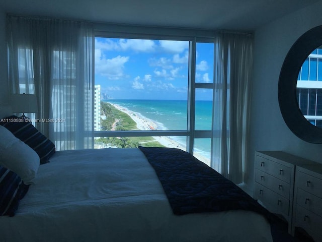 bedroom featuring multiple windows and a water view