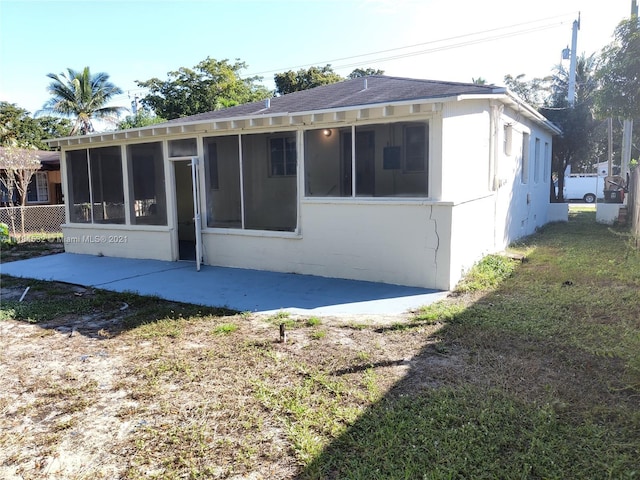 rear view of house with a sunroom and a patio