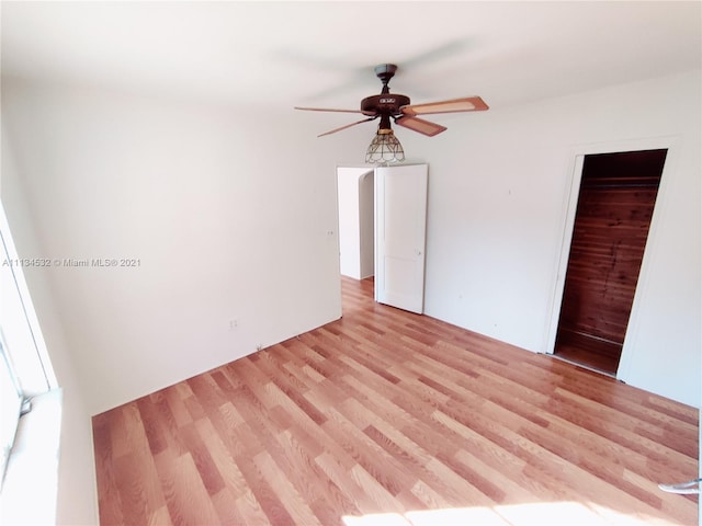 unfurnished bedroom featuring light hardwood / wood-style floors, a closet, and ceiling fan