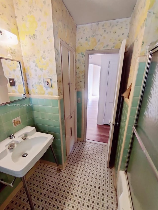 bathroom featuring tile floors, sink, and tile walls