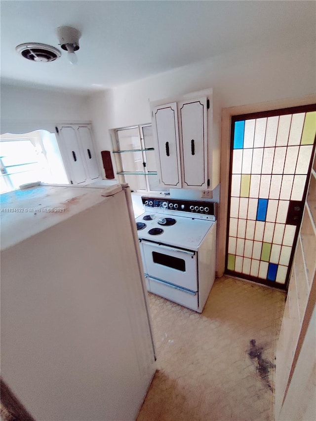 kitchen featuring refrigerator and white range with electric stovetop