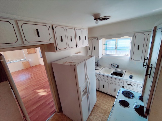 kitchen featuring white fridge with ice dispenser, sink, range, and light wood-type flooring