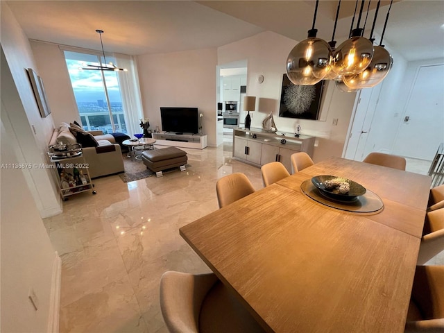 dining space featuring an inviting chandelier, a wall of windows, and light tile floors