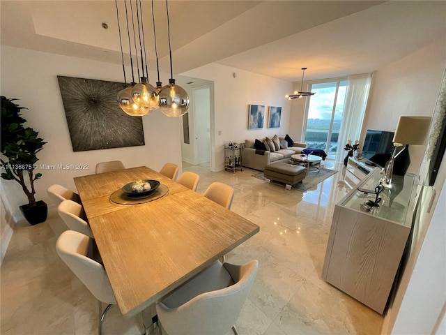 tiled dining room featuring expansive windows and a chandelier