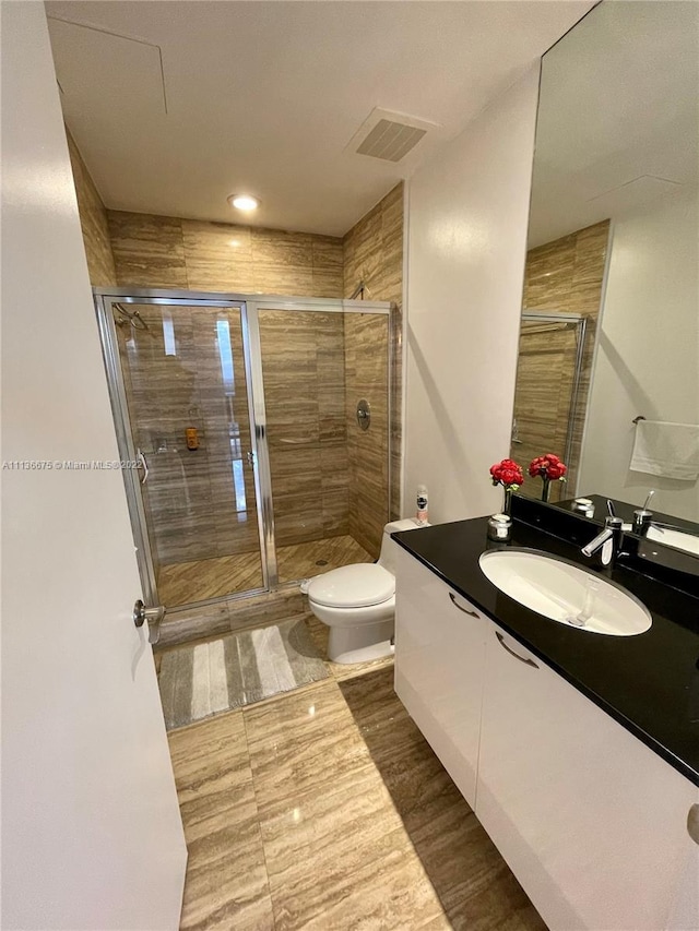 bathroom with tile floors, toilet, walk in shower, and oversized vanity