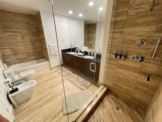 bathroom with double sink vanity, toilet, and a bidet