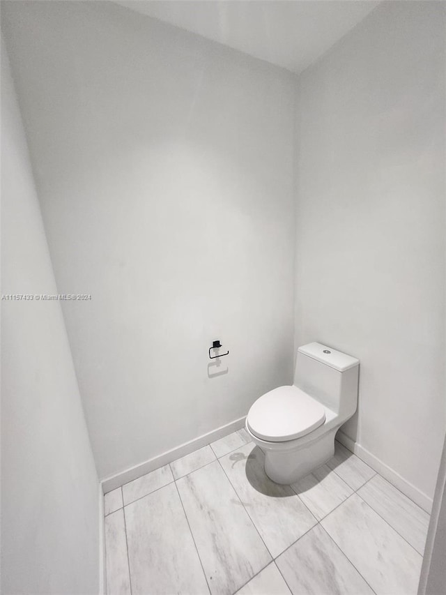 bathroom featuring toilet and tile floors