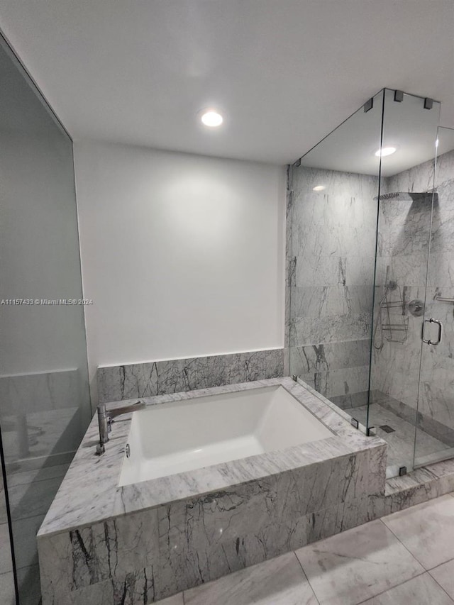 bathroom with shower with separate bathtub and tile floors