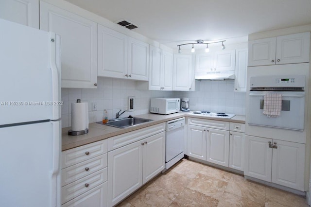 kitchen with light tile floors, tasteful backsplash, white appliances, white cabinets, and sink