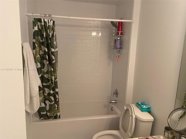 bathroom featuring shower / tub combo and toilet