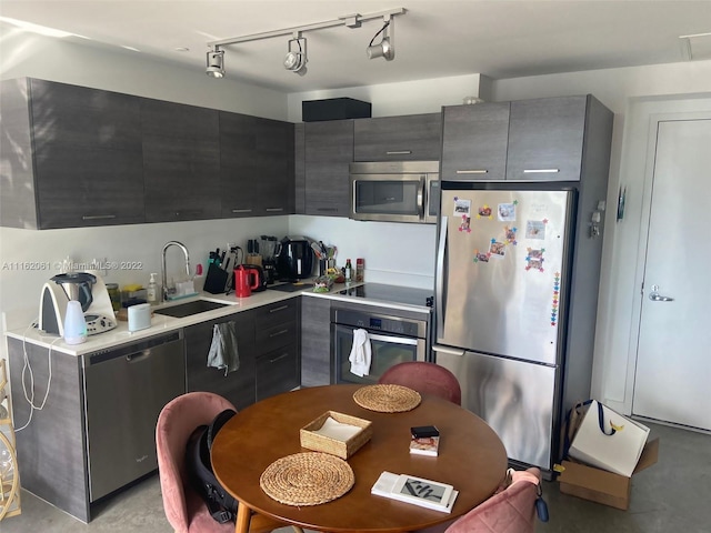 kitchen with rail lighting, appliances with stainless steel finishes, and sink