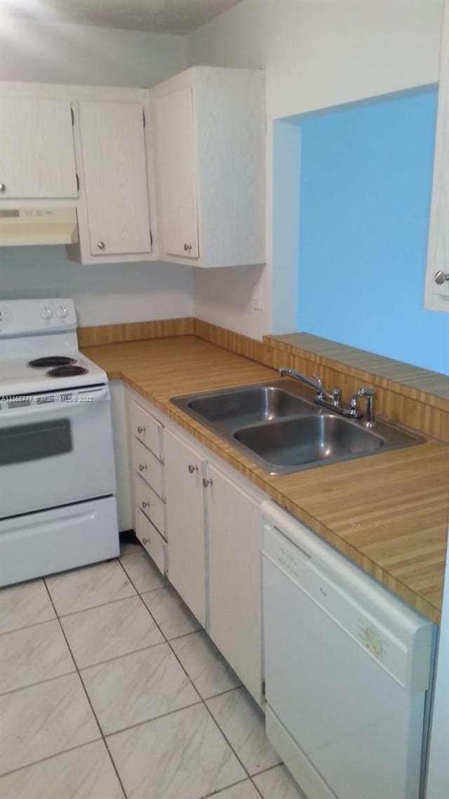 kitchen with white appliances, white cabinetry, extractor fan, and sink