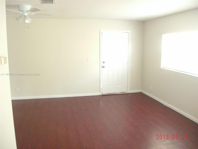 spare room featuring a textured ceiling, dark hardwood / wood-style flooring, and ceiling fan