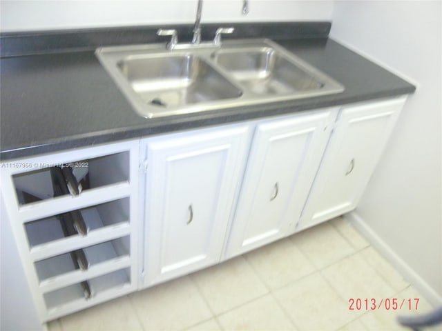 interior details featuring wine cooler, white cabinetry, and sink