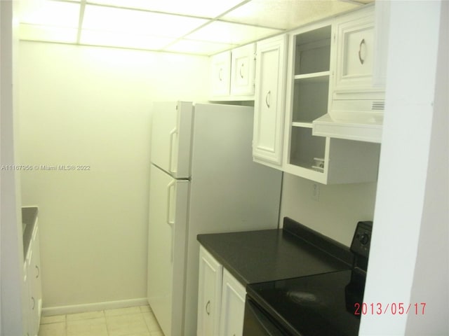 kitchen with a drop ceiling, ventilation hood, white refrigerator, white cabinets, and black / electric stove