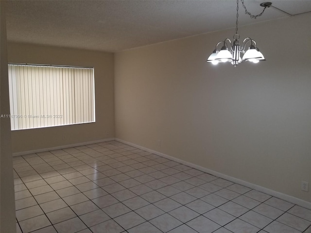 tiled empty room featuring a notable chandelier