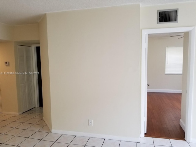 empty room featuring a textured ceiling and light hardwood / wood-style floors