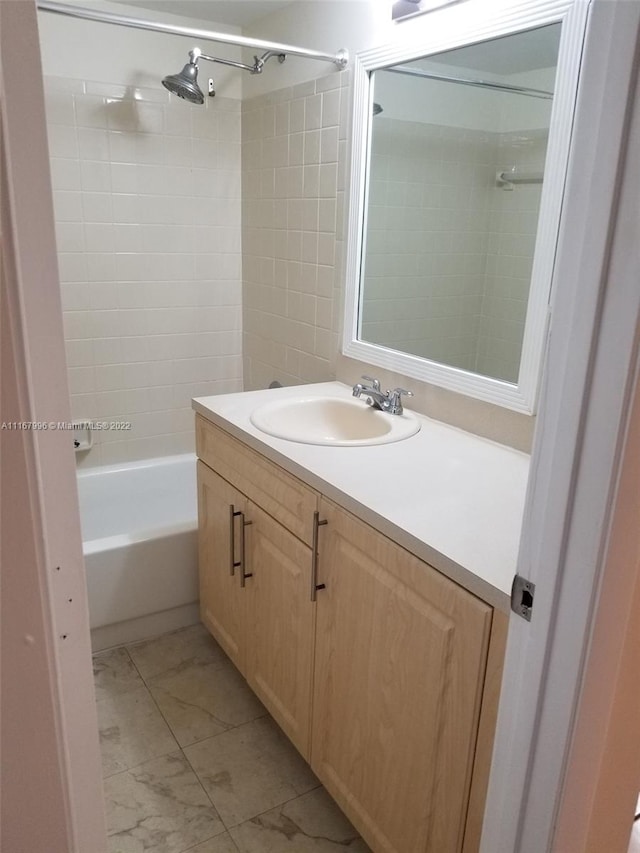 bathroom featuring vanity and tiled shower / bath