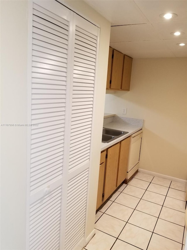 kitchen featuring dishwasher, light tile patterned flooring, and sink