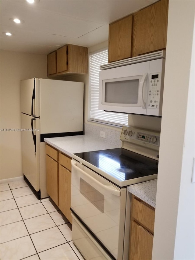 kitchen with white appliances and light tile patterned flooring