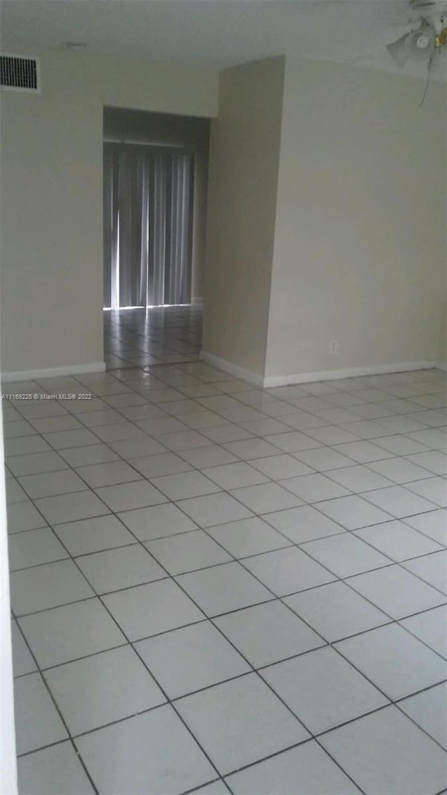 tiled empty room featuring ceiling fan